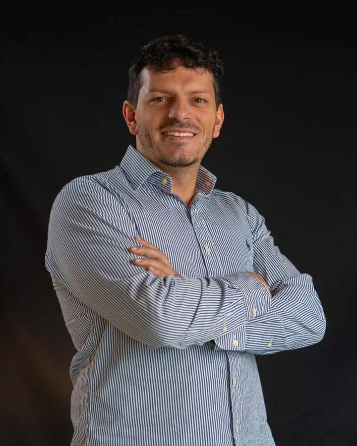 Natan, da AeroConcierge, de camisa listrada e braços cruzados